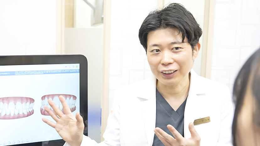 松戸で歯並びの矯正相談を行う院長と、説明を受ける矯正歯科患者